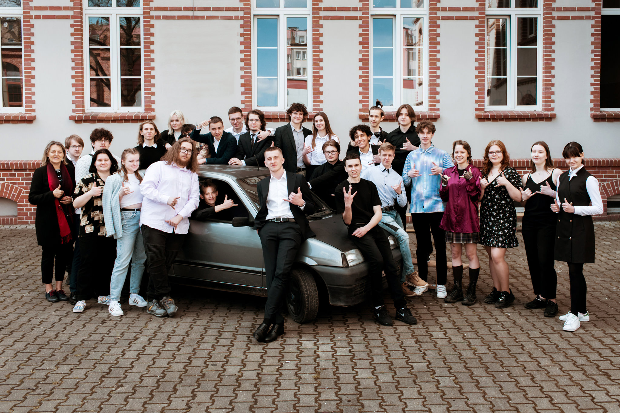 Zdjęcia klasowe Wrocław – kreatywna sesja grupowa uczniów szkoły średniej przed budynkiem szkoły